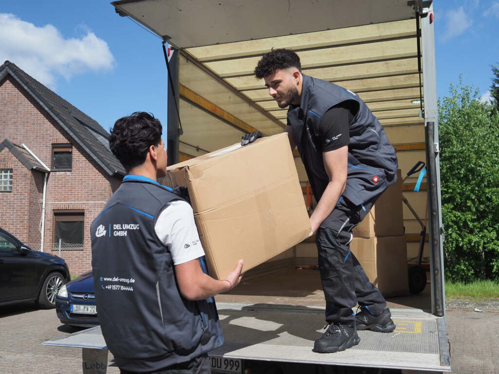 DEL UMZUG Mitarbeiter verladen einen Umzugskarton